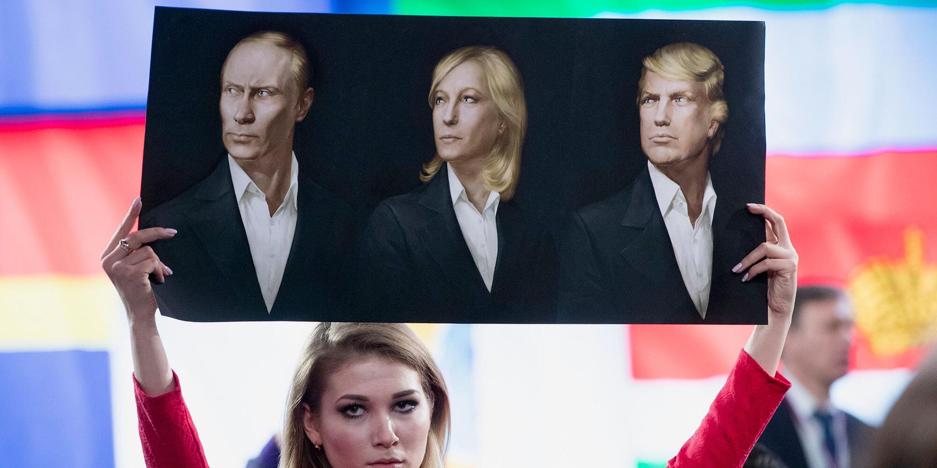 Журналист держит плакат с портретами Владимира Путина, Марин Ле Пен и Дональда Трампа - ИноСМИ, 1920, 22.07.2024