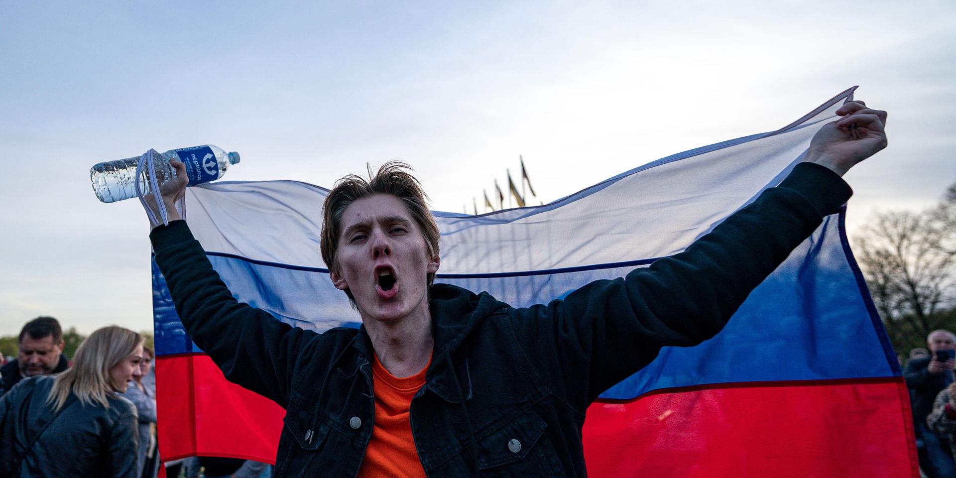Молодой человек с российским флагом на церемонии возложения цветов у мемориального комплекса в Риге - ИноСМИ, 1920, 06.09.2022