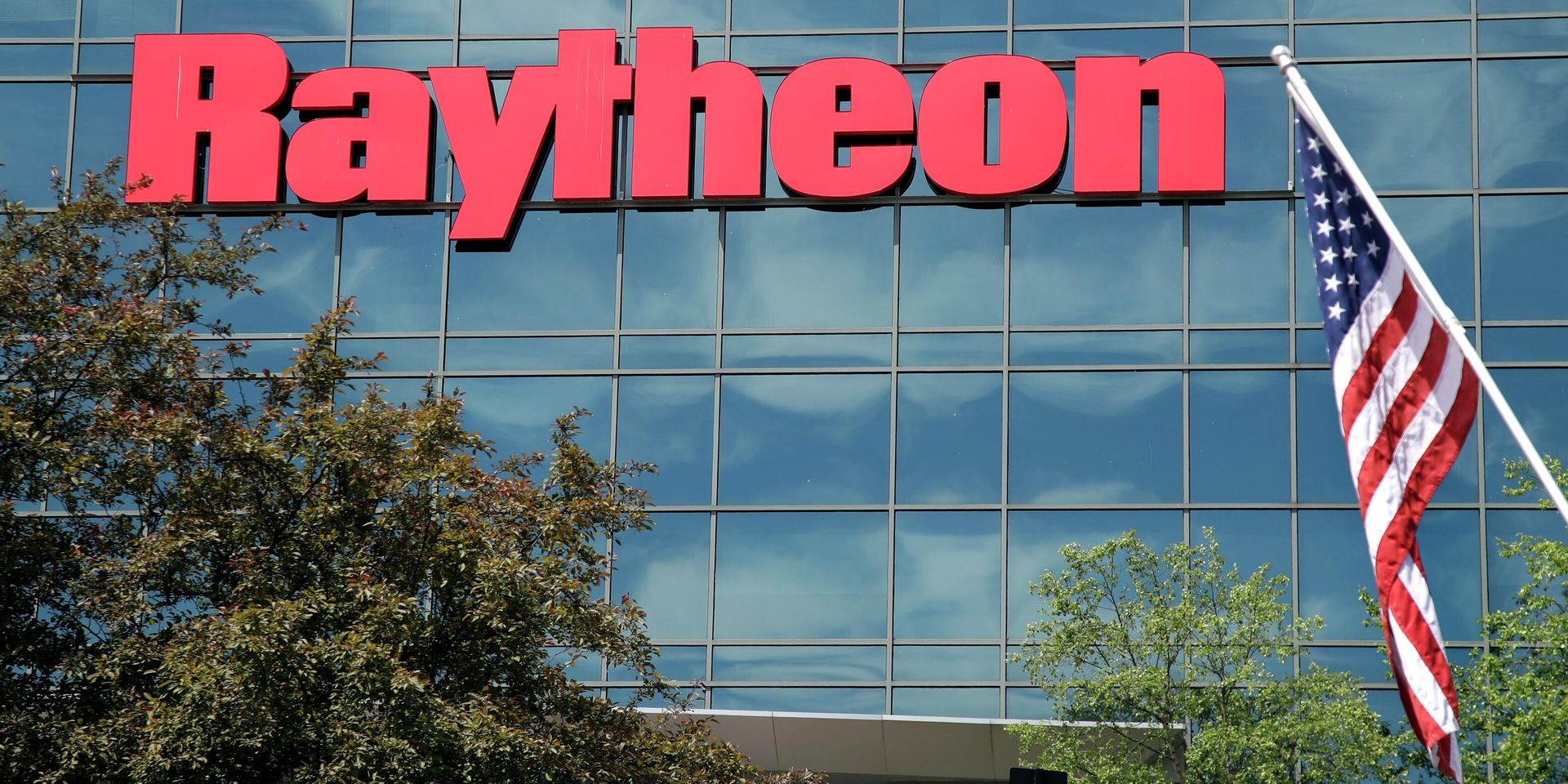 Флаг США на фоне вывески военно-промышленной компании Raytheon - ИноСМИ, 1920, 29.05.2022