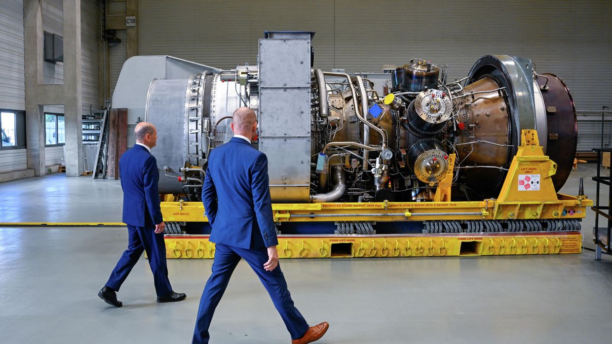 Канцлер Германии Олаф Шольц и президент Siemens Energy Кристиан Брух осматривают турбину для Северного потока 1 на завод Siemens Energy в Мюльхайм-на-Руре, Германия