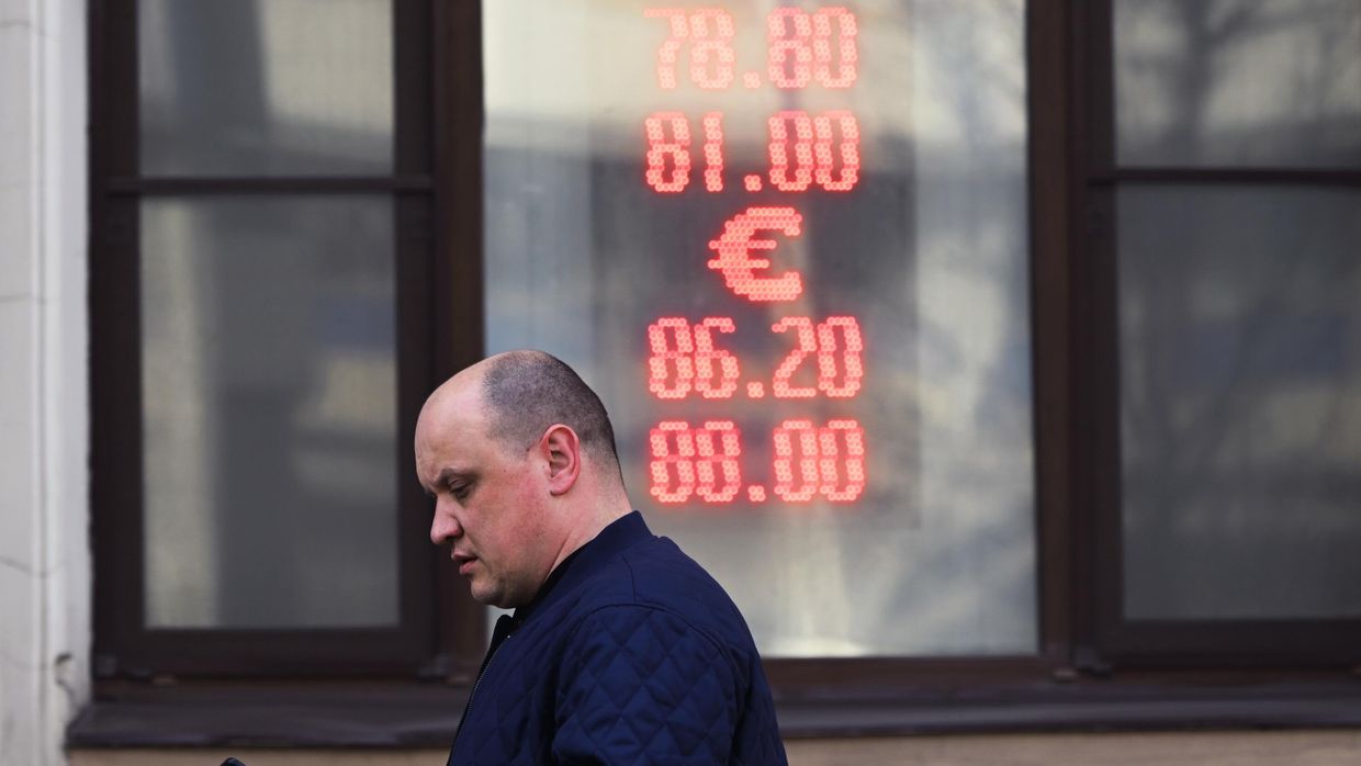 Мужчина проходит мимо пункта обмена валют в Москве
