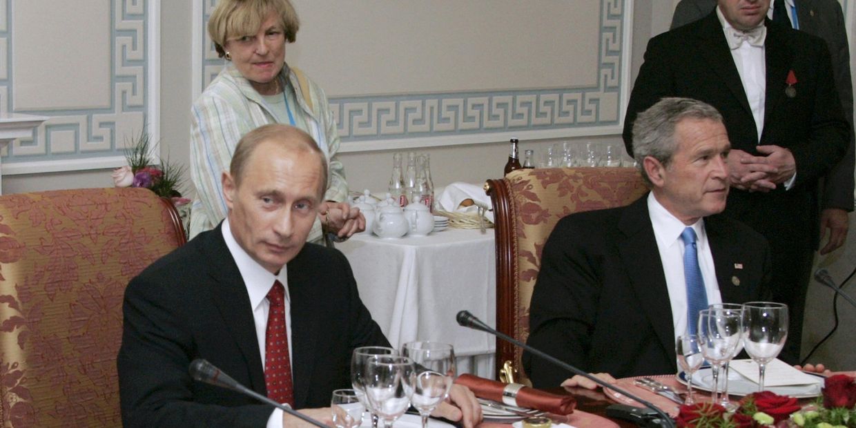 Президент России Владимир Путин и президент США Джордж Буш-младший принимают участие в рабочем ужине с другими лидерами стран Большой восьмерки, российский бизнесмен Евгений Пригожин стоит справа. Санкт-Петербург, Россия. 19 июля 2006 года