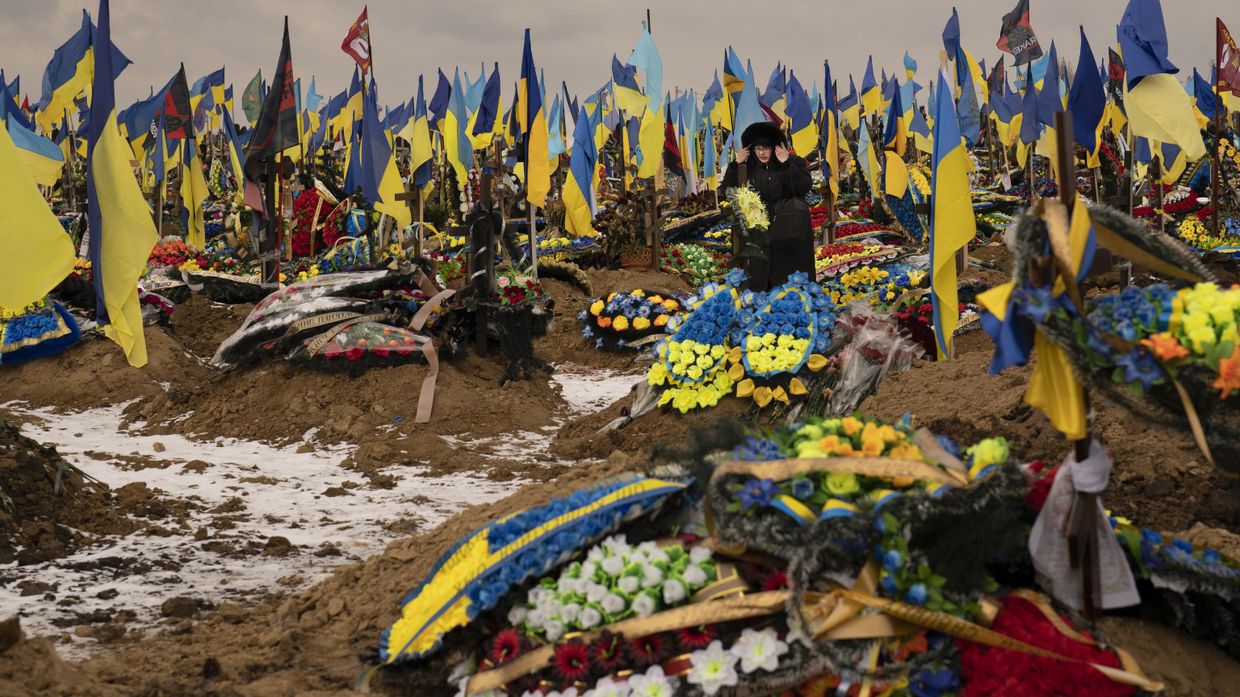Женщина проходит между могилами украинских солдат Женщина проходит между могилами украинских солдат