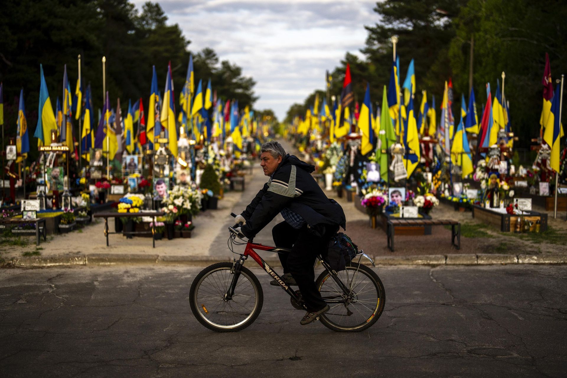 Велосипедист проезжает мимо могил украинских солдат, погибших во время боевых действий, на Лесном кладбище в Киеве - ИноСМИ, 1920, 25.03.2026