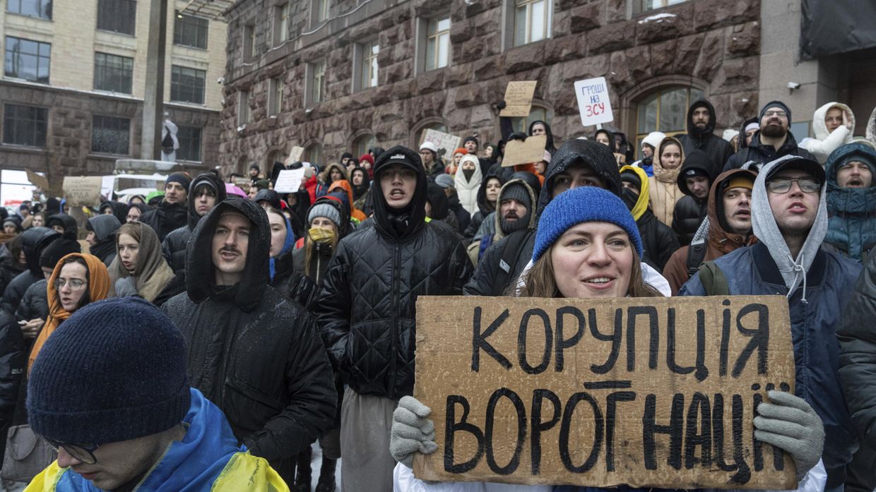 Активистка держит плакат с надписью Коррупция - враг нации во время акции протеста перед зданием городского совета Киева