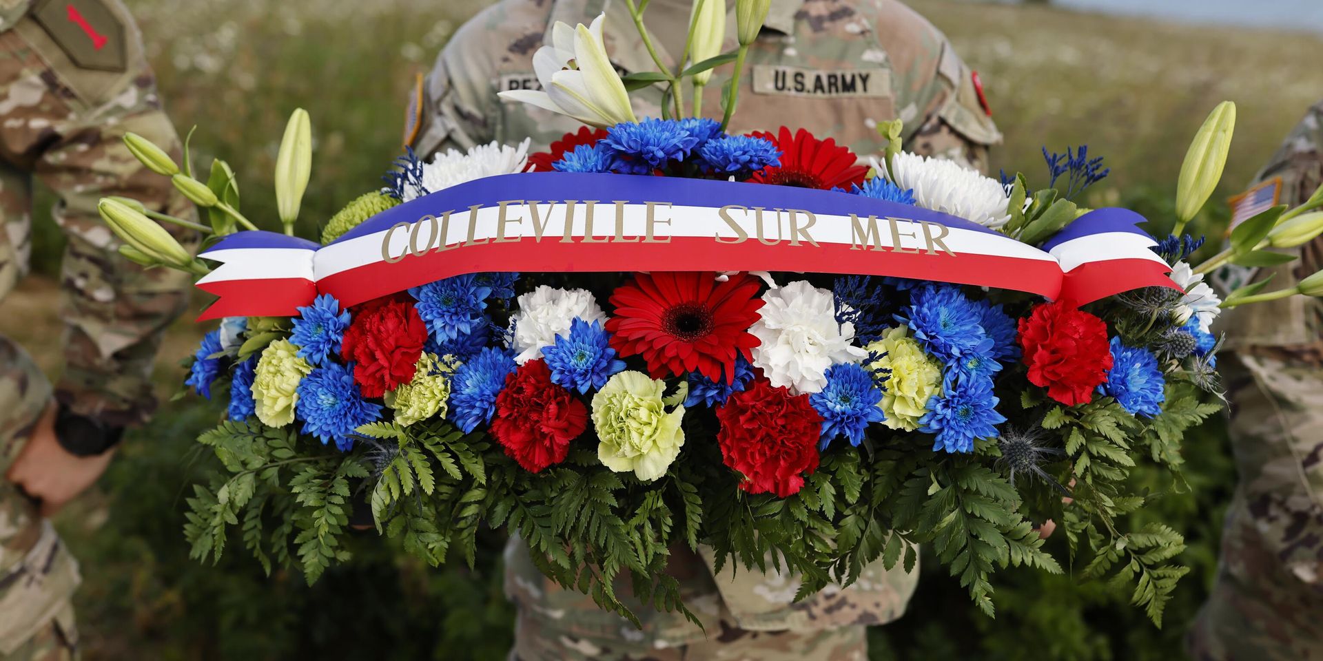 Американский солдат держит венок из цветов во время церемонии возложения венков к памятнику 1-й пехотной дивизии в рамках церемоний, посвященных 80-й годовщине Дня Д недалеко от пляжа Омаха, Нормандия - ИноСМИ, 1920, 06.06.2024