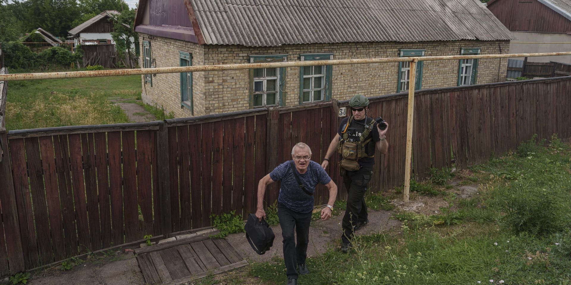 Сотрудник украинской полиции из подразделения Белые ангелы сопровождает пожилого мужчину к фургону во время эвакуации в безопасные районы в городе Торецке Донецкой области - ИноСМИ, 1920, 01.12.2024