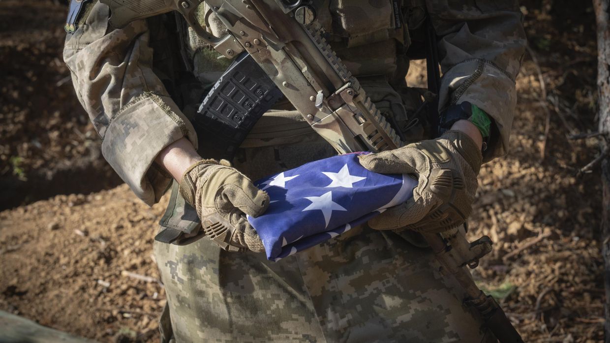 Американский наемник - боец ВСУ, держит в руках флаг США