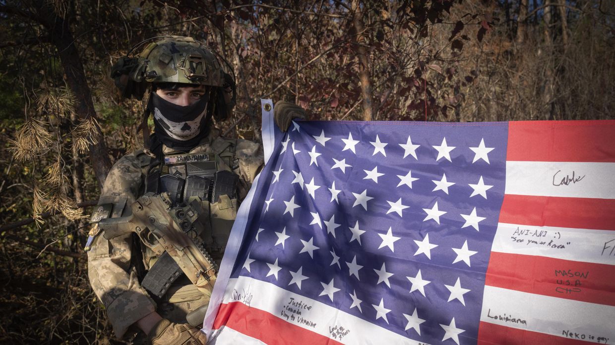 25-летний наемник с позывным Дима из Техаса держит флаг США на своей позиции недалеко от линии фронта в Харьковской области, Украина