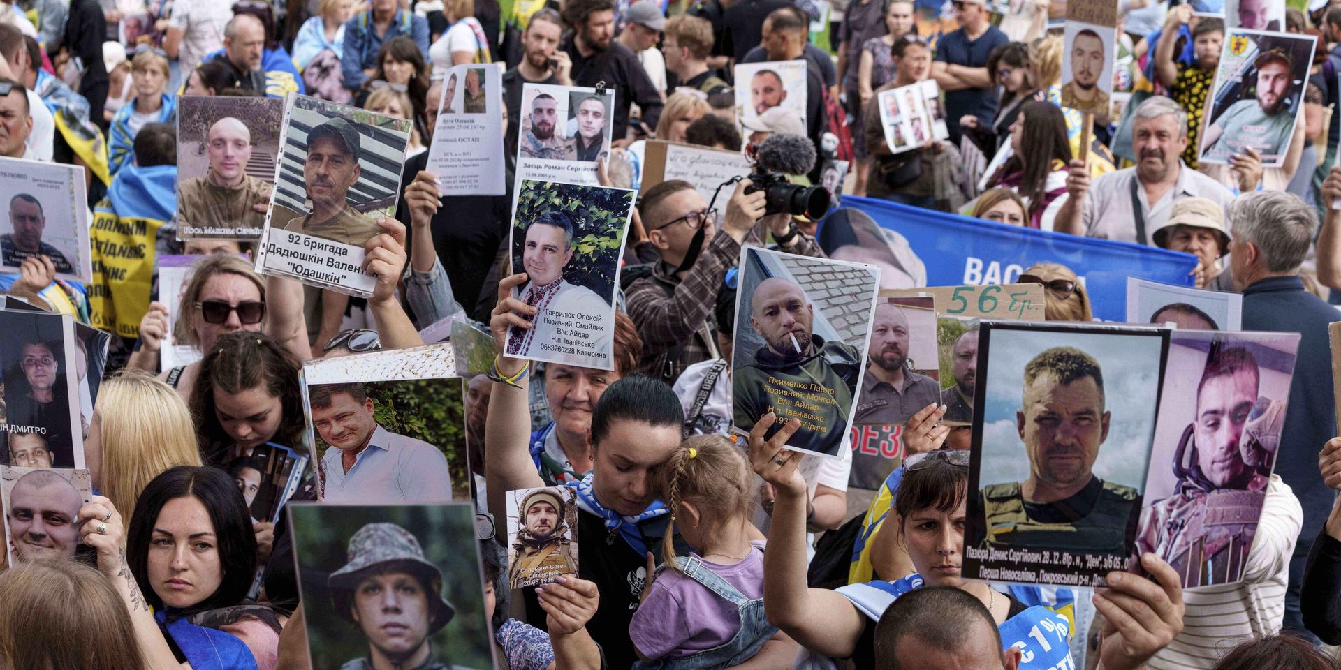 Украинцы держат в руках фотографии своих пропавших на фронте без вести родственников, встречая возвращающихся из плена солдат во время обмена между Россией и Украиной 9 июня 2025 года. - ИноСМИ, 1920, 08.08.2025