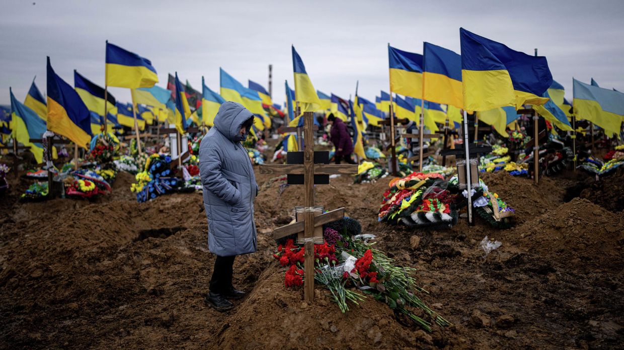 Женщина у могилы своего мужа, погибшего на передовой, на кладбище в Харькове, Украина Женщина у могилы своего мужа, погибшего на передовой, на кладбище в Харькове, Украина
