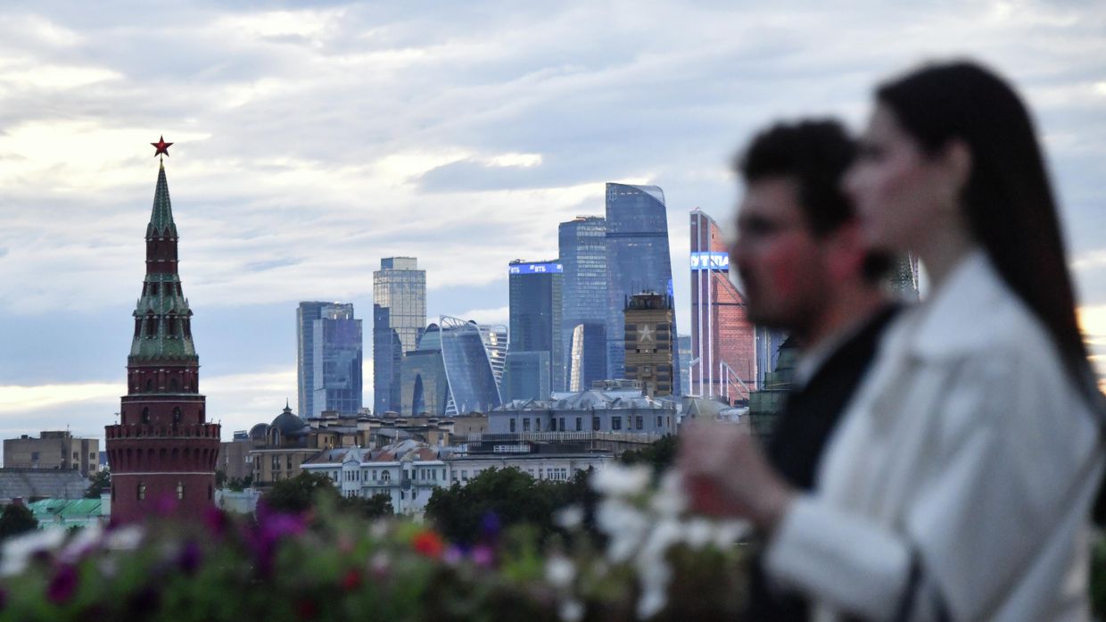 Молодой человек с девушкой идут по Большому Москворецкому мосту в Москве