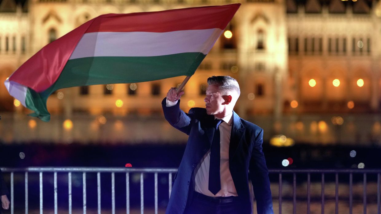 Петер Мадьяр, победивший на парламентских выборах в Венгрии, держит флаг Венгрии после объявления предварительных результатов