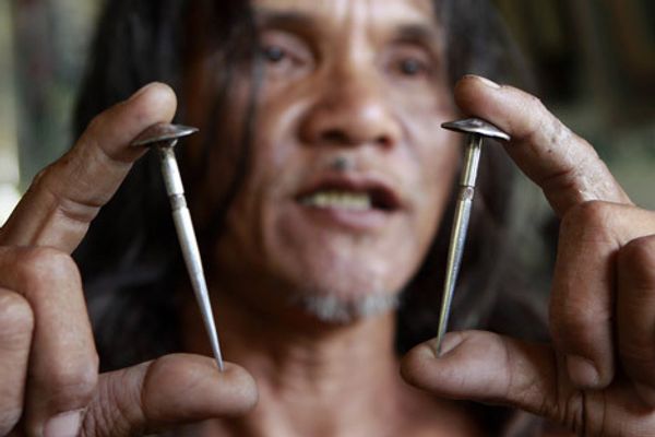 Кающийся Рубен Эньяж показывает две трехдюймовых стальных гвоздя, сделанных на заказ, которые будет использоваться для его распятие в Страстную пятницу в Катуд, Сан-Фернандо Пампанга в северной части Филиппин