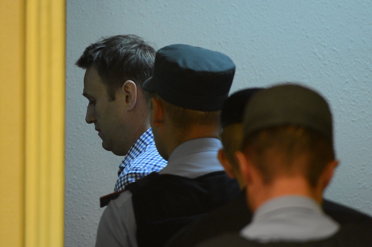 Сотрудники полиции уводят из зала суда Алексея Навального
