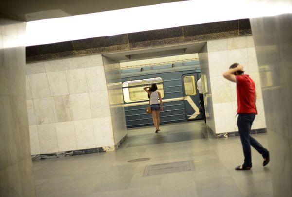 Молодые люди поправляют прически на станции метро в Москве