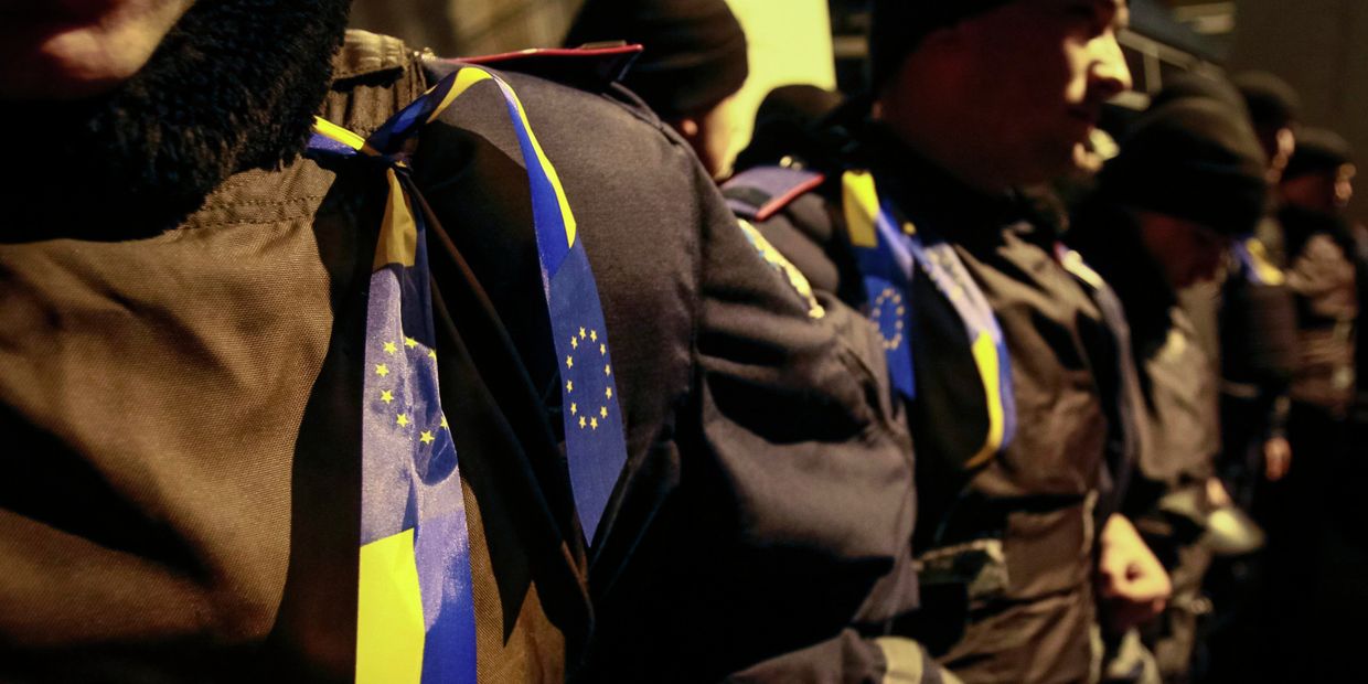 Ленты с украинскими флагами и флагами Евросоюза на полицейских во время митинга в поддержку евроинтеграции, Киев Ленты с украинскими флагами и флагами Евросоюза на полицейских во время митинга в поддержку евроинтеграции, Киев