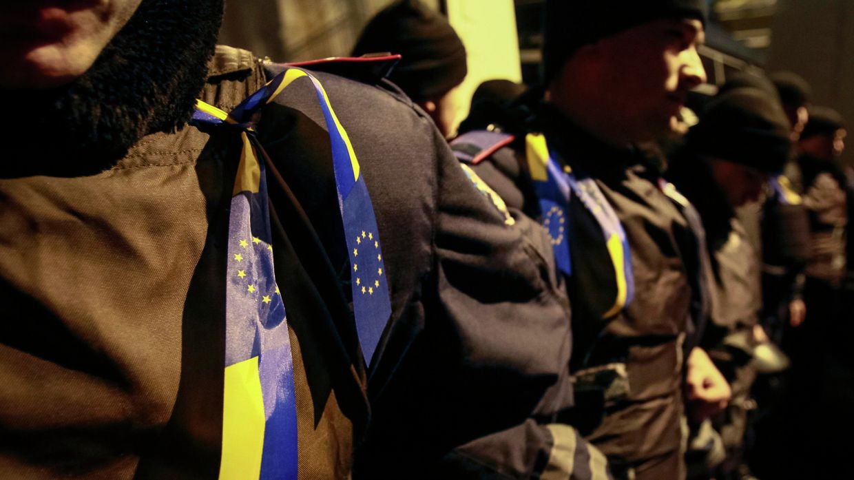 Ленты с украинскими флагами и флагами Евросоюза на полицейских во время митинга в поддержку евроинтеграции, Киев