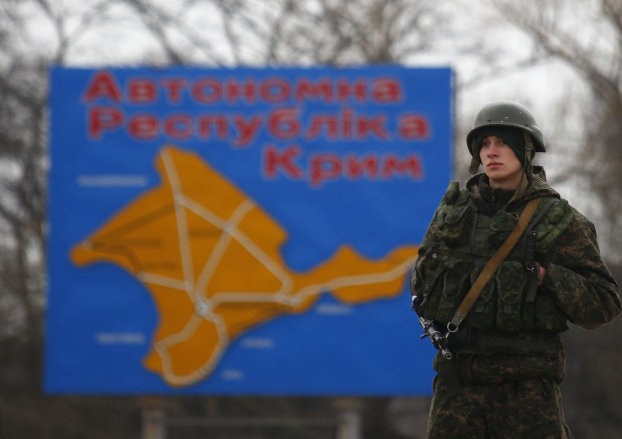 Российский военнослужащий на фоне карты Крыма рядом с городом Керчь Российский военнослужащий на фоне карты Крыма рядом с городом Керчь