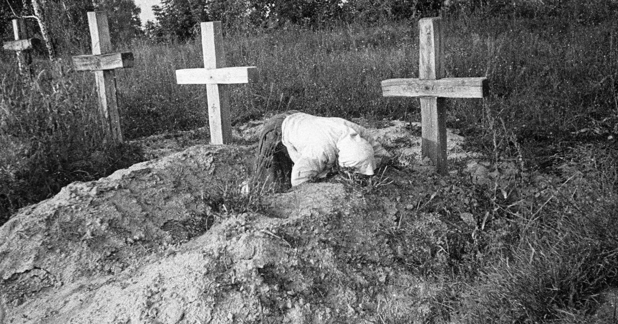 Женщина плачет на могиле своего близкого Женщина плачет на могиле своего близкого