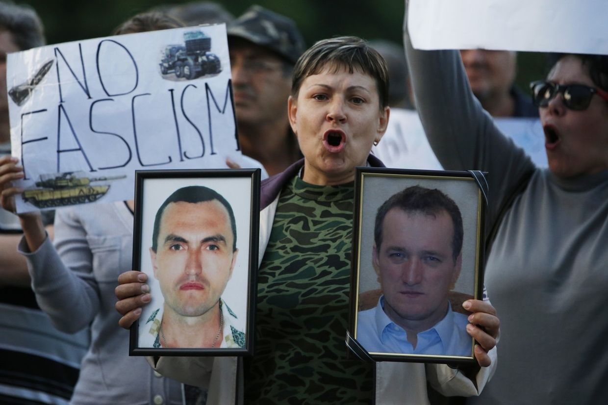 Женщина с портретами людей, погибших в столкновениях на востоке Украины, на пророссийском митинге в Донецке
