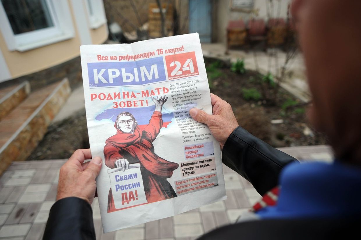 Житель Крыма читает газету, поддерживающую референдум 16 марта Житель Крыма читает газету, поддерживающую референдум 16 марта