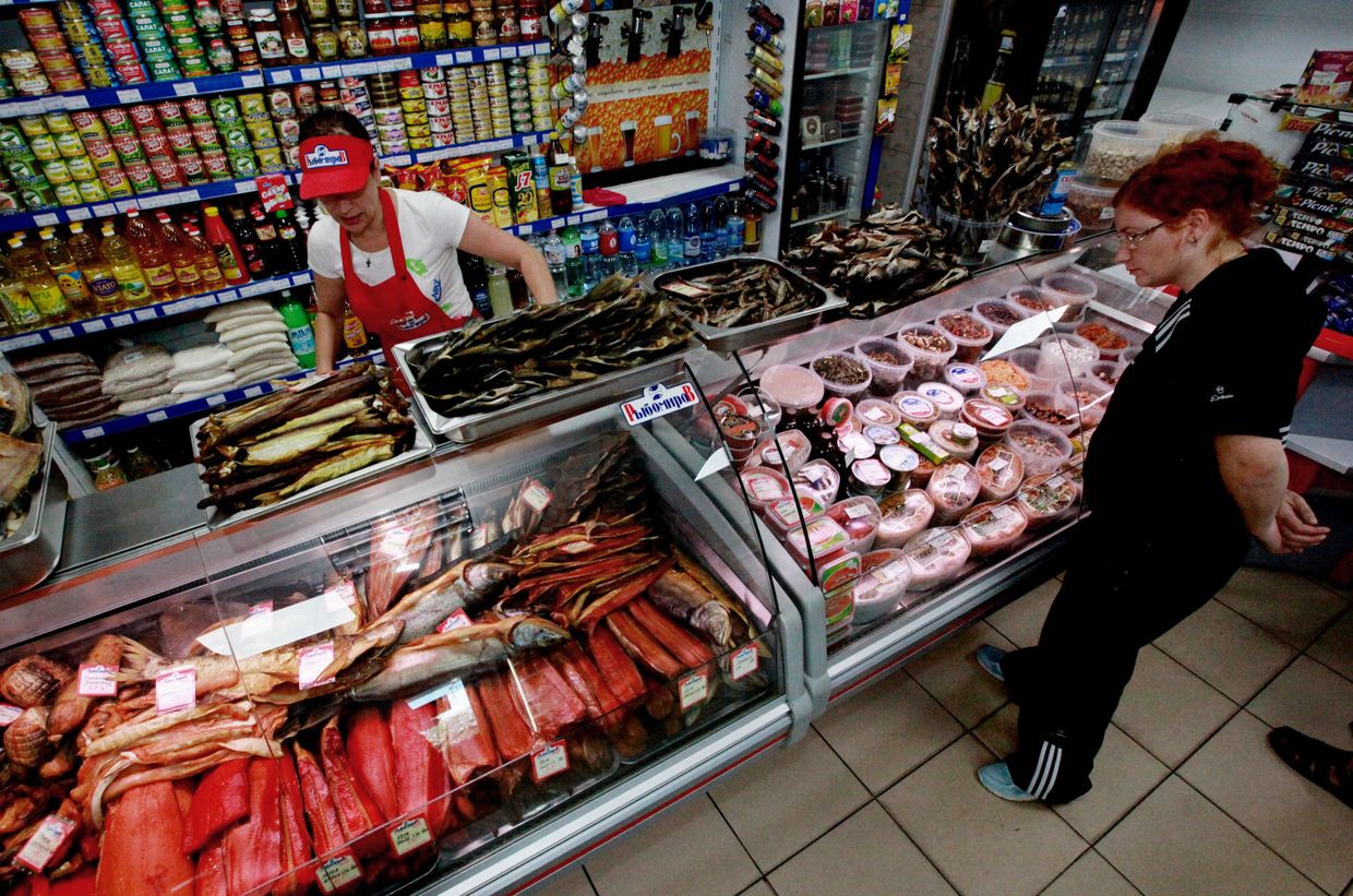 Женщина рассматривает рыбную продукцию в магазине