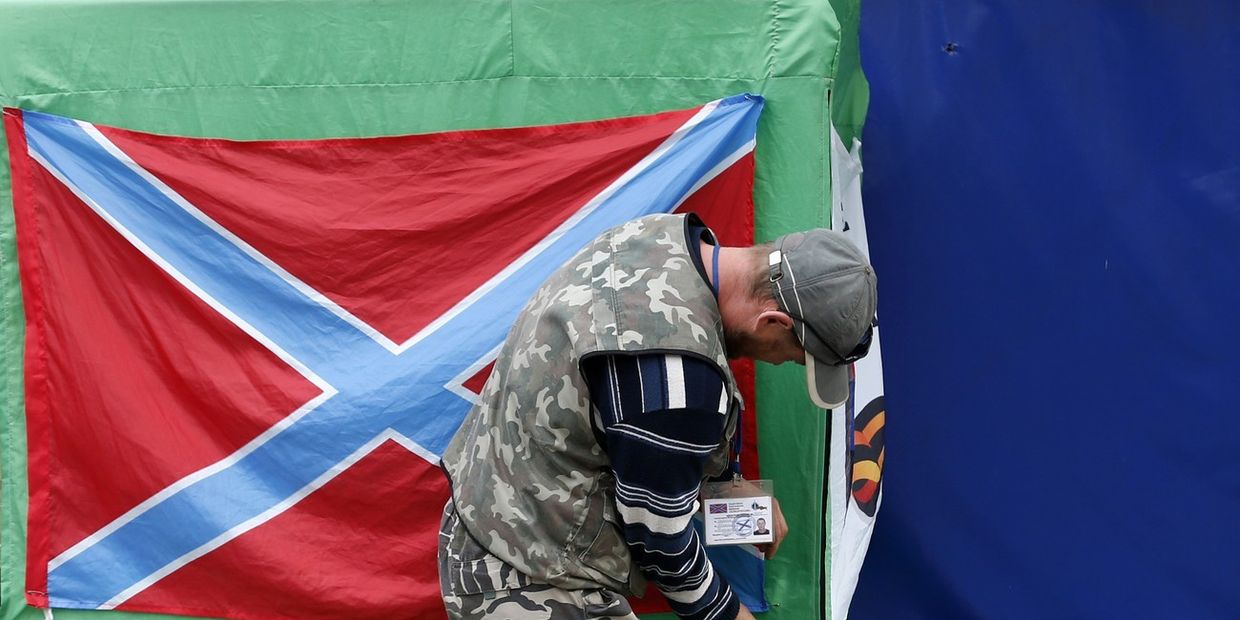 Ополченец вешает флаг Новороссии в Донецке