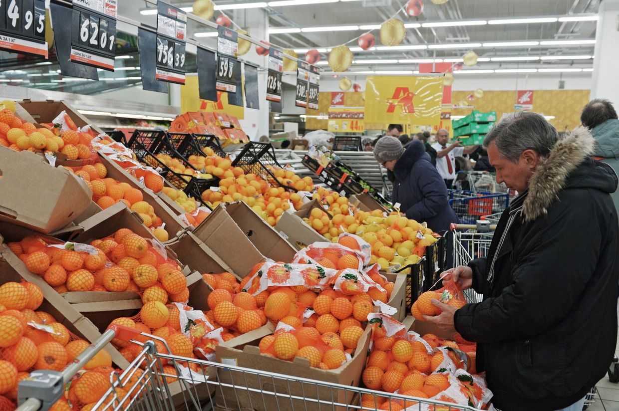 Посетитель выбирает фрукты в одном из магазинов торговой сети «Ашан» в Москве