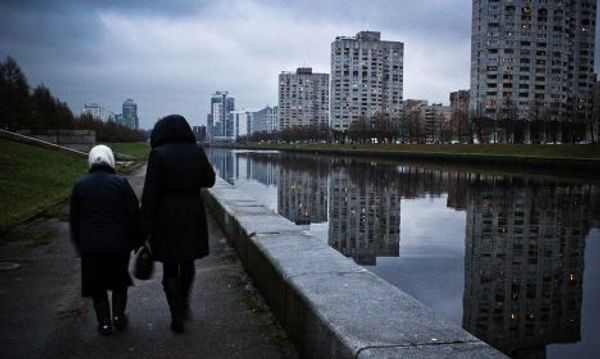 Женщины идут по набережной на Наличной улице в Санкт-Петербурге