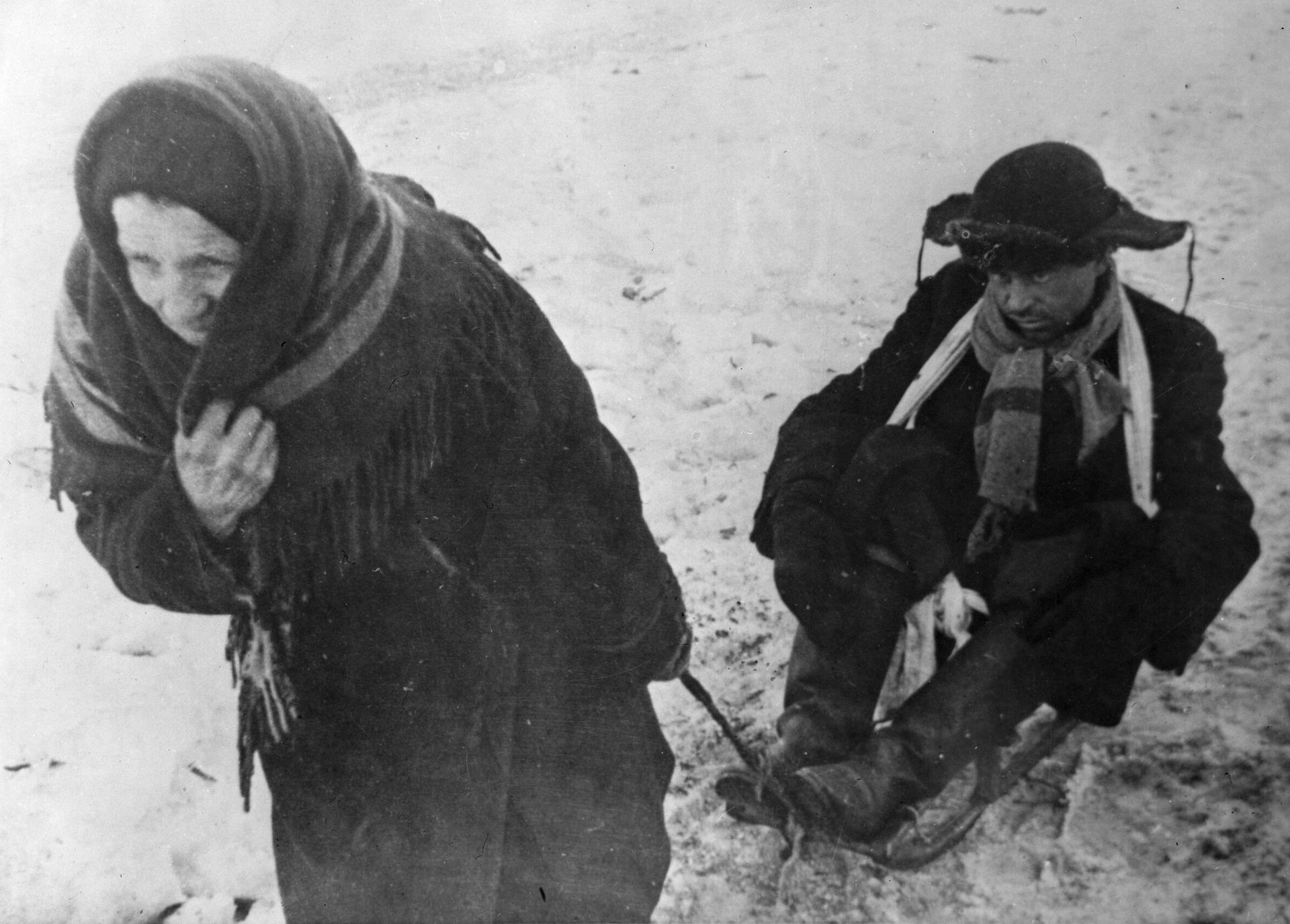 Жители блокадного Ленинграда: женщина везет ослабевшего от голода мужа на санках - ИноСМИ, 1920, 27.01.2021