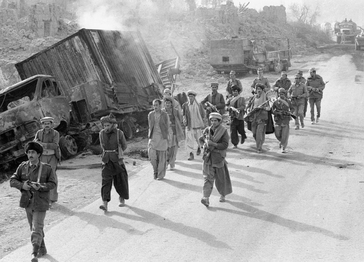 Бойцы царандоя (народной милиции Афганистана) и советские военнослужащие конвоируют захваченных в плен моджахедов