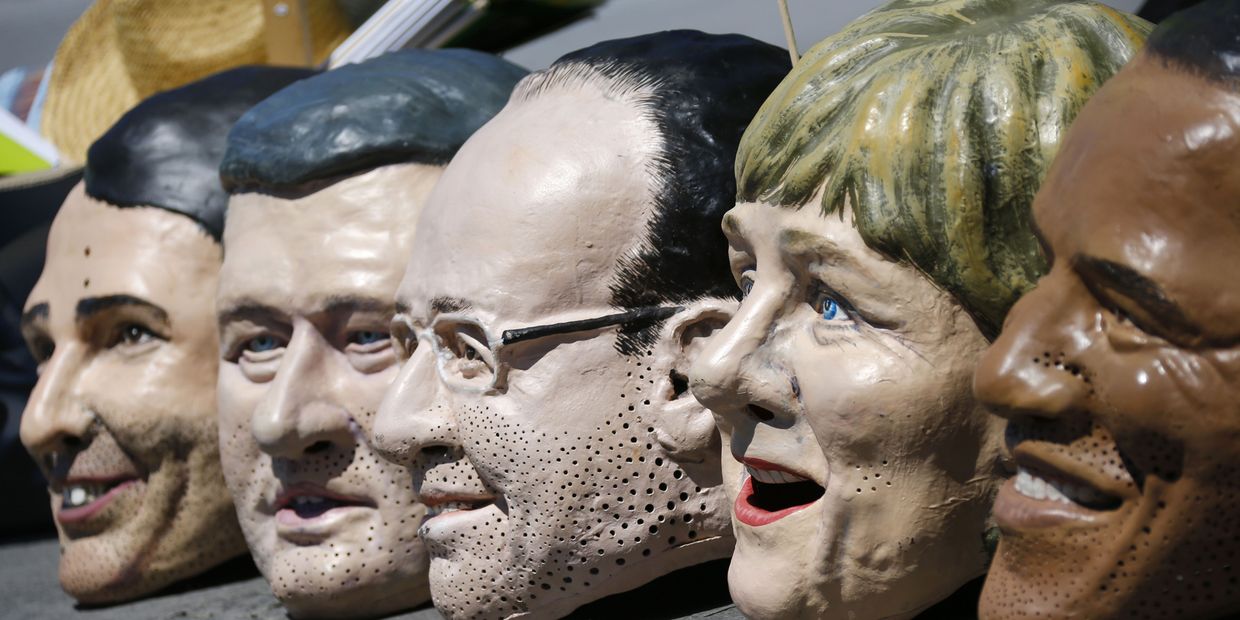 Маски с лицами участников саммита G7 во время акции протеста в Мюнхене