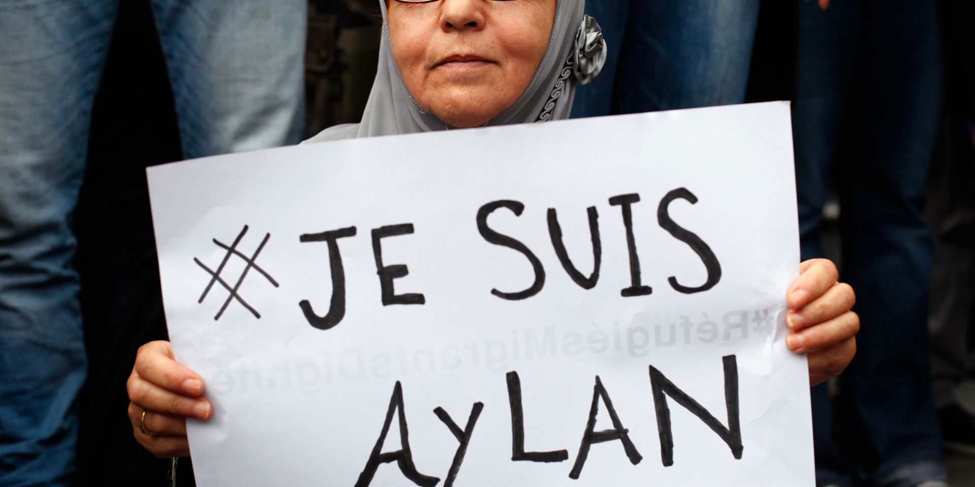 Женщина с плакатом Je suis Aylan на митинге в поддержку беженцев в Париже - ИноСМИ, 1920, 29.05.2026
