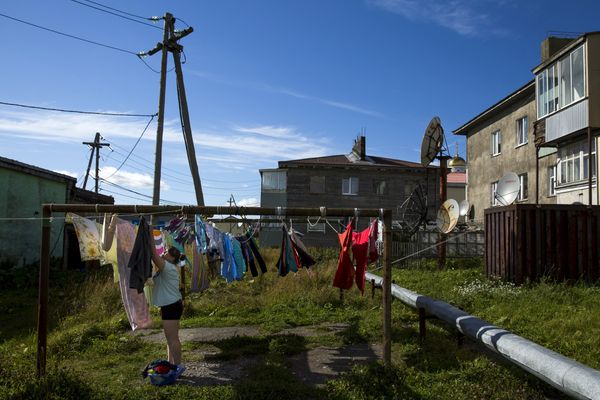 Женщина вешает белье в центре Южно-Курильска