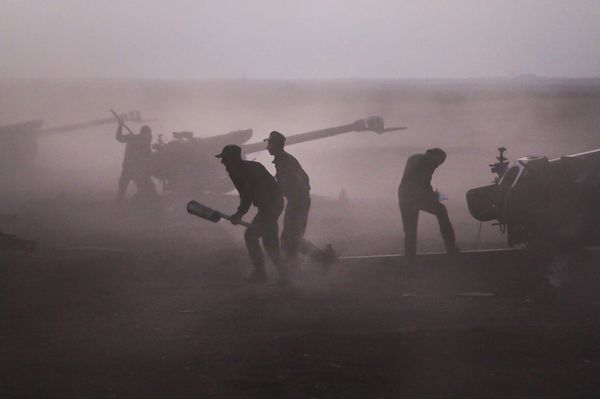 Военнослужащие сирийской армии загружают гаубицы рядом с деревней Морек