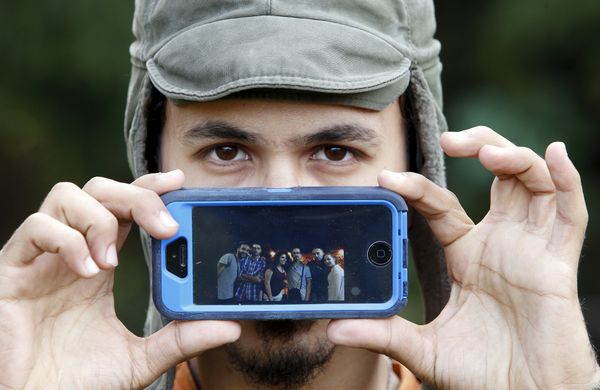Мухаммад, беженец из Дамаска, показывает фотографию своих лучших друзей