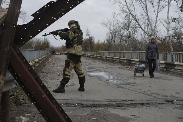 Ополченец на отремонтированном мосту, соединяющем подконтрольные государству и повстанцам территории