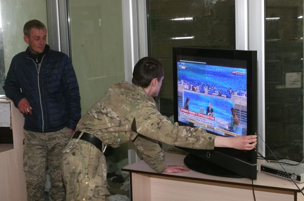 Ополченцы ДНР настраивают телевизор для просмотра ежегодной специальной программы «Прямая линия с Владимиром Путиным»