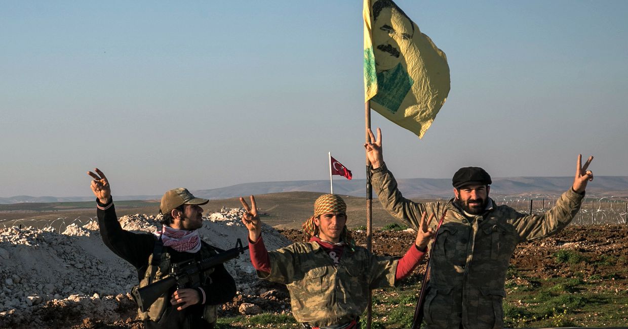Бойцы курдских Отрядов народной самообороны (YPG) с портретом лидера Рабочей партии Курдистана Абдуллы Оджалана