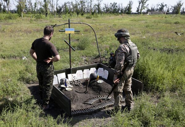 Украинские военные возле импровизированного мемориала их товарищам, погибшим здесь же, рядом с Авдеевкой, Донецкая область Украинские военные возле импровизированного мемориала их товарищам, погибшим здесь же, рядом с Авдеевкой, Донецкая область