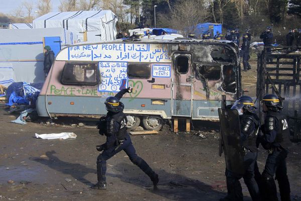 Сотрудники полиции во время беспорядков в лагере мигрантов Джунгли возле Кале, Франция