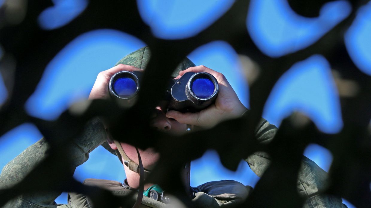 Российский военный смотрит в бинокль