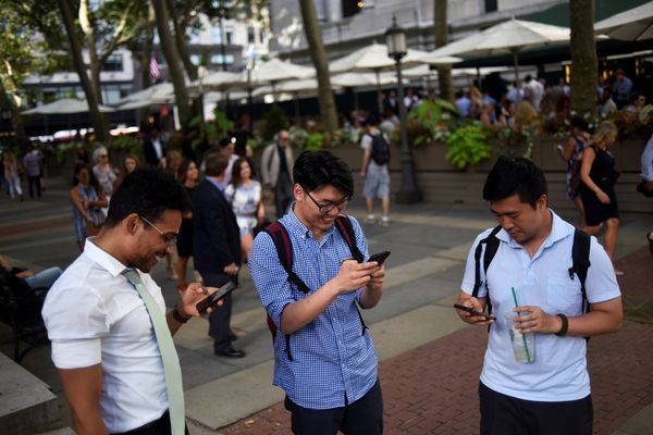 Люди играют в Pokemon GO на своих смартфонах в парке Брайант в Нью-Йорке