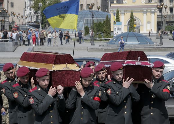 Украинские солдаты несут гробы с телами сослуживцев