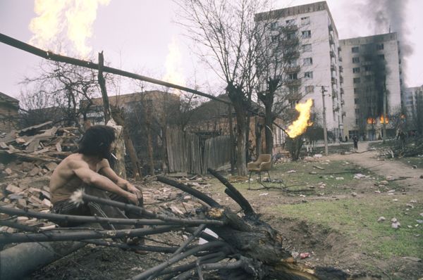 Житель Грозного смотрит на горящие дома