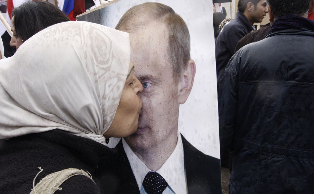 Сирийская женщина целует портрет президента РФ Владимира Путина