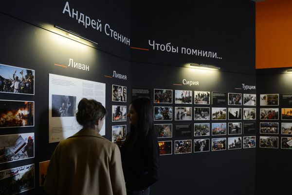 Сотрудники МИА «Россия сегодня» у экспозиции фотографий корреспондента Андрея Стенина