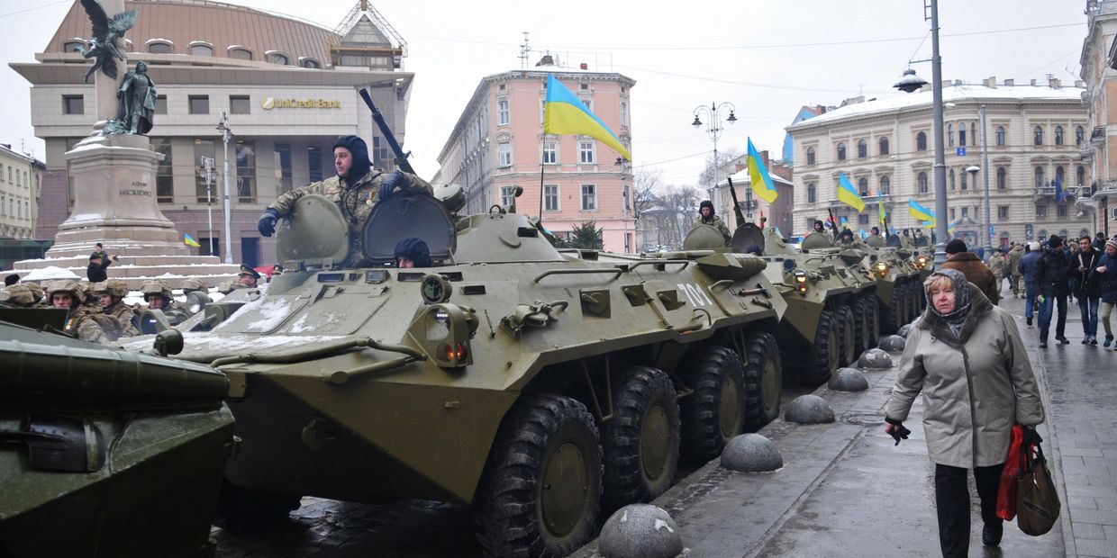 Горожане у колонны бронетехники перед началом Марша защитников Украины, по случаю празднования 25-й годовщины Вооруженных сил Украины, во Львове