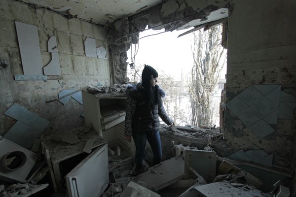 Девушка в квартире, разрушенной от попадание снаряда в результате обстрела, в Киевском районе Донецка